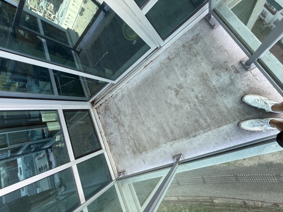 Balcony before cleaning &mdash; grime along the slab edges and mottled staining across the middle.