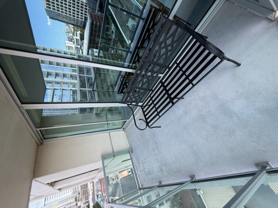 Balcony after cleaning &mdash; the staining lifted and the floor an even tone, cushions removed for the clean.