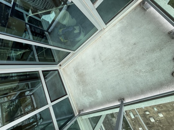 Balcony before cleaning &mdash; dirt worked into the corners and a dulled, patchy floor surface.