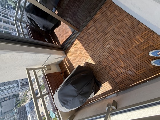 Balcony after cleaning &mdash; the same deck tiles cleaned back to a warm orange-brown, grain visible.