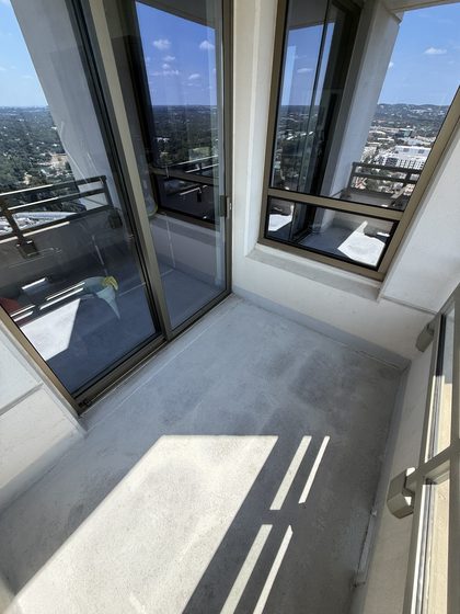 Balcony after cleaning &mdash; debris cleared and staining lifted to a lighter, more even grey.