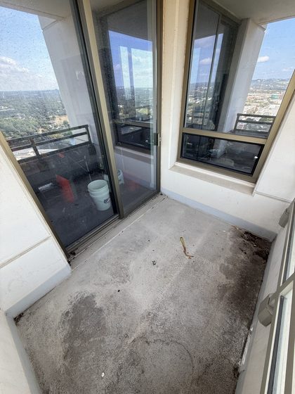 Balcony before cleaning &mdash; leaf debris, soil, and dark organic staining across the floor and corners.